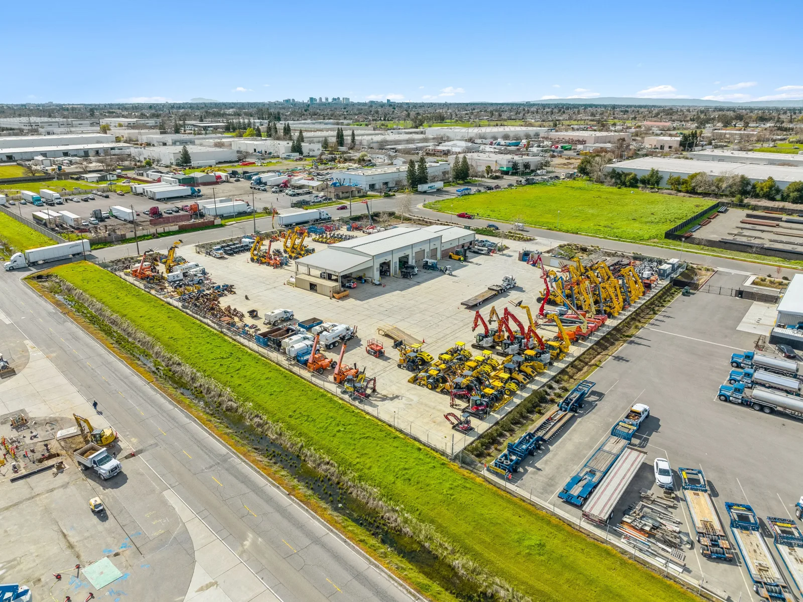 Aerial view of an industrial outdoor storage yard with trucks and equipment